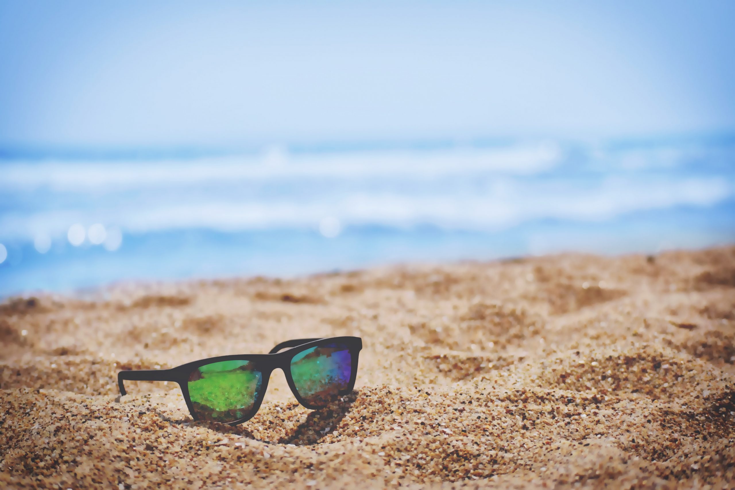 Picture of sunglasses on a beach from Unsplash